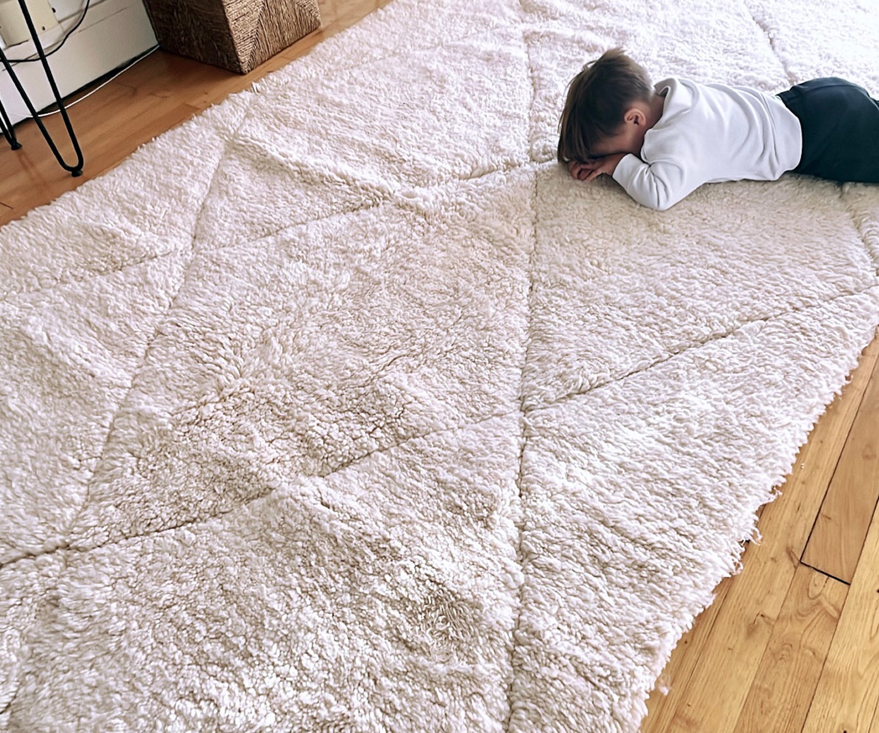 Enfant assis sur un tapis Beni Ouarain blanc